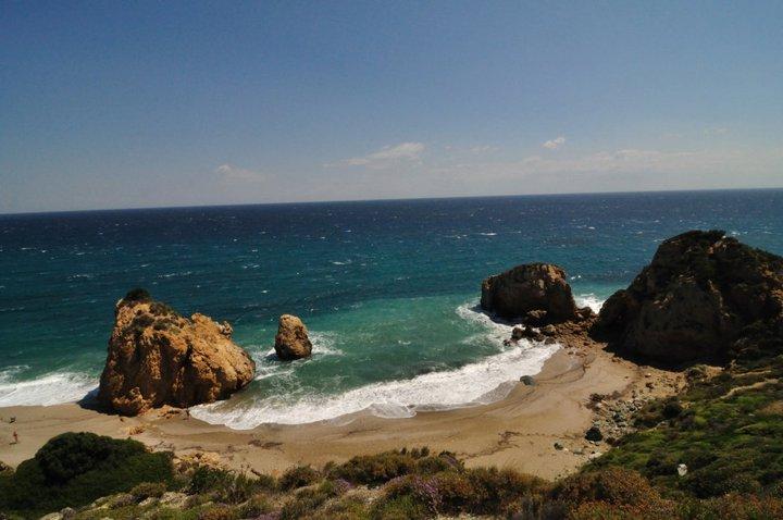 Η ειρηνική και ατελείωτη αμμουδερή παραλία των Ποτιστικών στο Πήλιο, με την καταγάλανη θάλασσα και το πράσινο του βουνού στο βάθος.